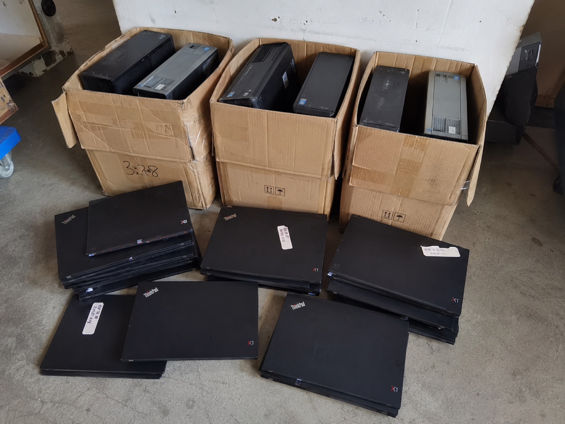 紙箱與地面分類擺放的 ThinkPad 與桌面電腦